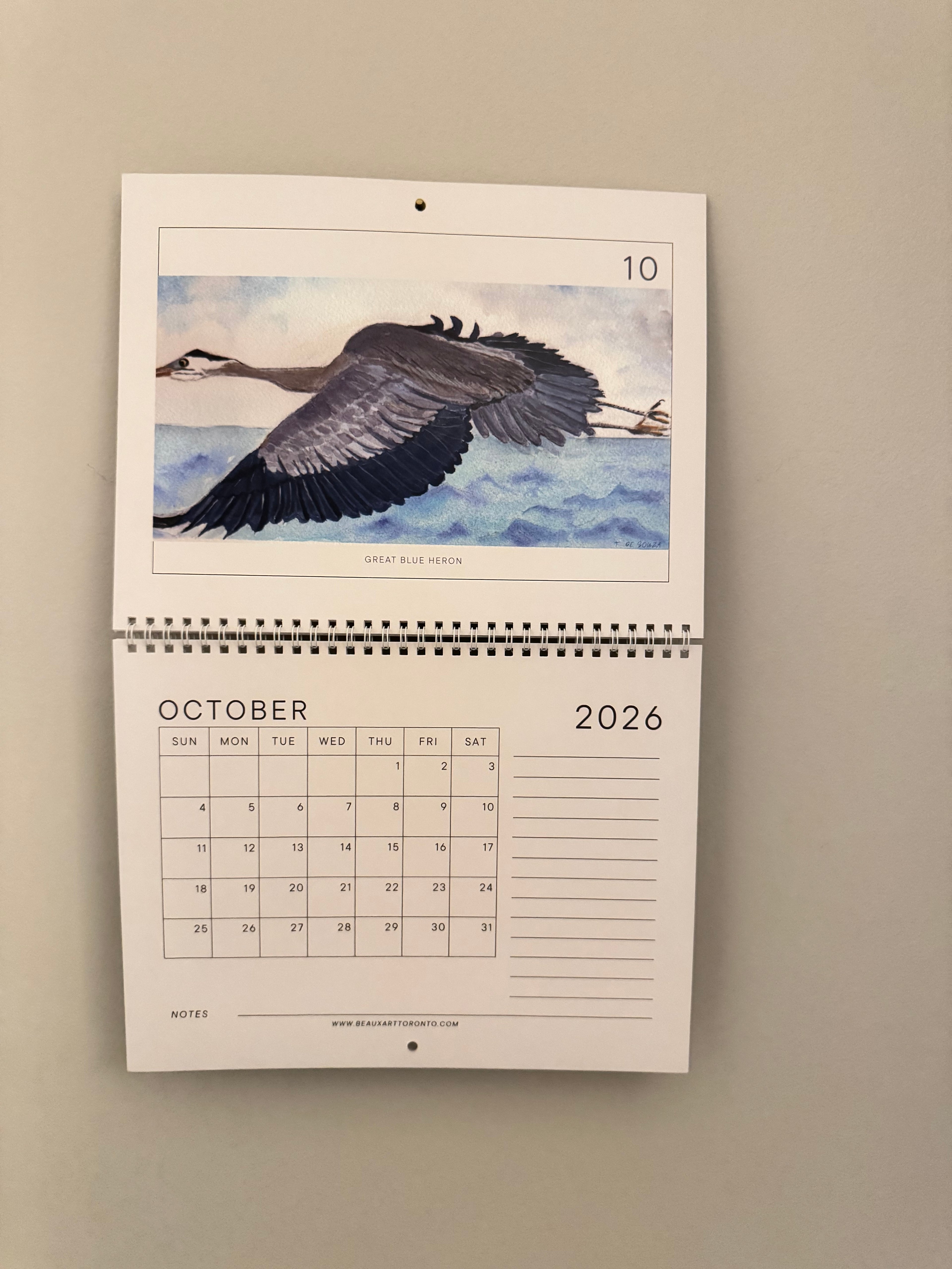 Calendar open to October 2026 with an illustration of a bird on a beige background